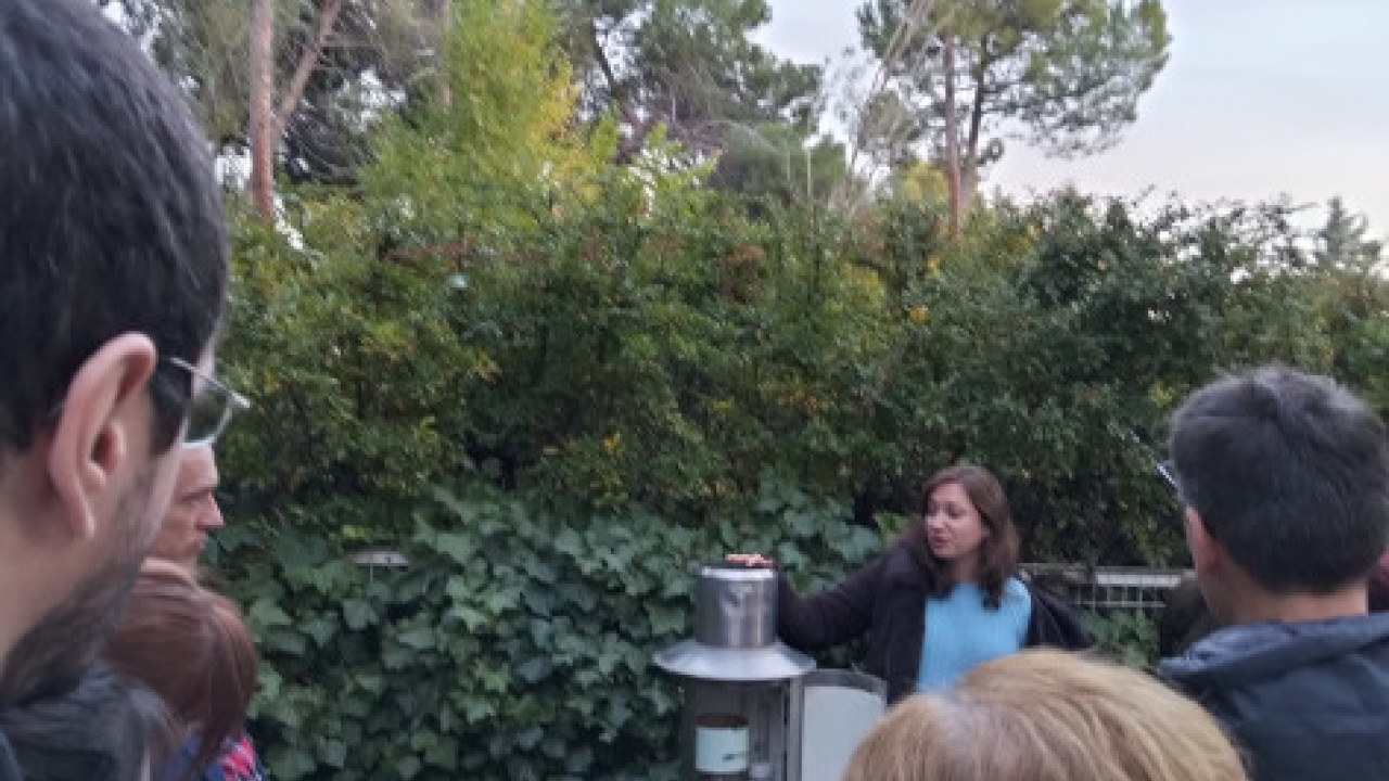 Una compañera de AEMET explica al público asistente los fundamentos de un pluviógrafo.