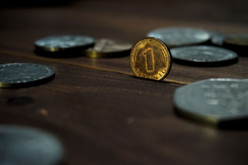 Moneda de un penique sobre una mesa de manera donde hay otras siete monedas de plata