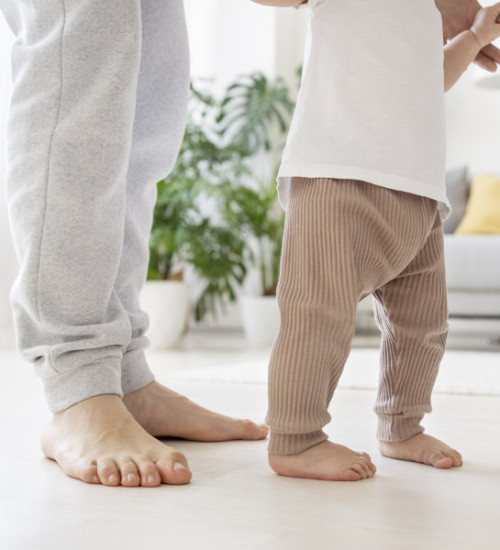 Bebé dando sus primeros pasos descalzo 